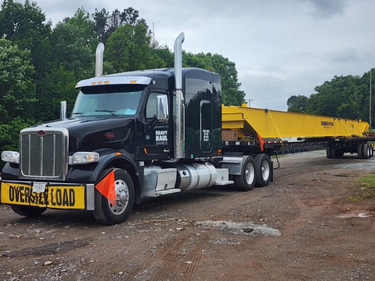 Semi tractor with oversize load placard hauling yellow beam