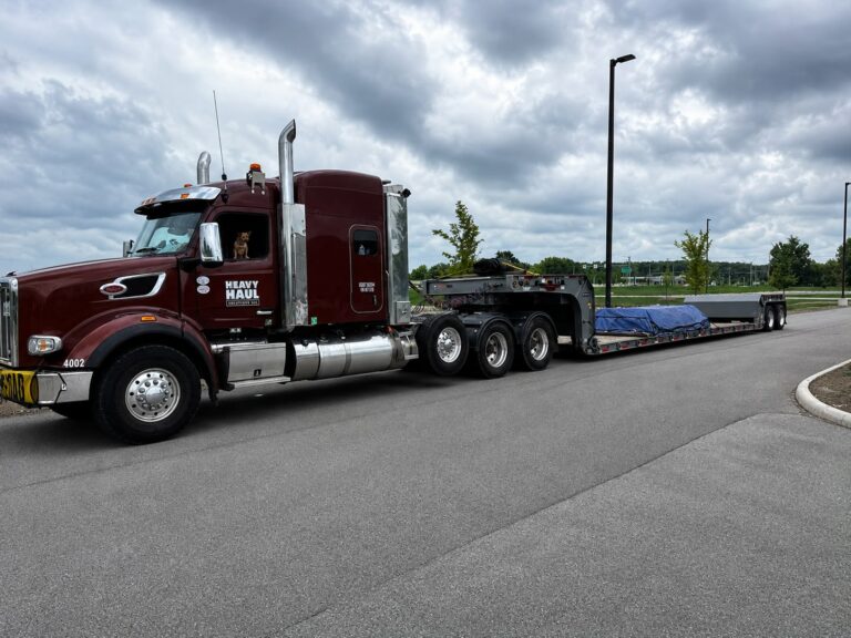 Semi tractor with Heavy Haul Solutions branding towing a low boy trailer.